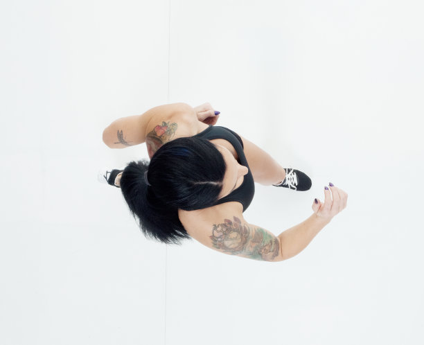 身穿运动服的白人女性在白色背景前追逐图片下载