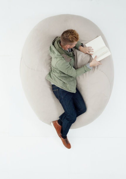 白人十几岁的男孩大学学生躺在前面的白色背景穿着夹克和拿教科书图片下载