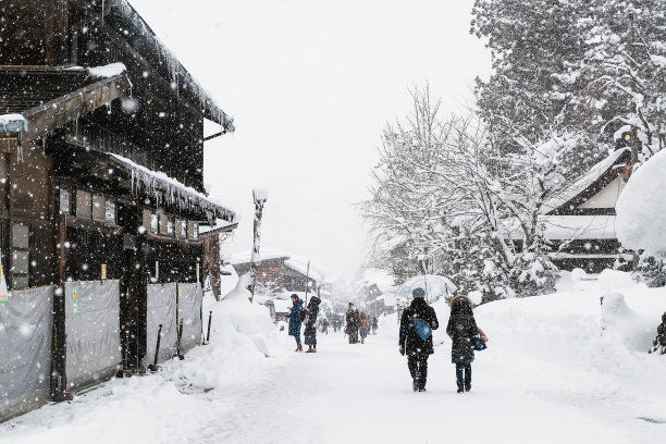 游客们在白川村散步。在日本白川市的冰天雪地里。图片下载