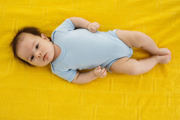 一个可爱的小男孩躺在家里的床上图片下载