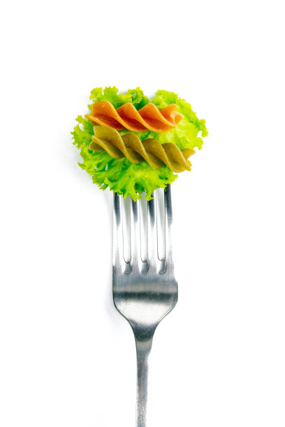 用叉子叉着莴苣叶的意大利面食，在白色的背景上吃图片下载