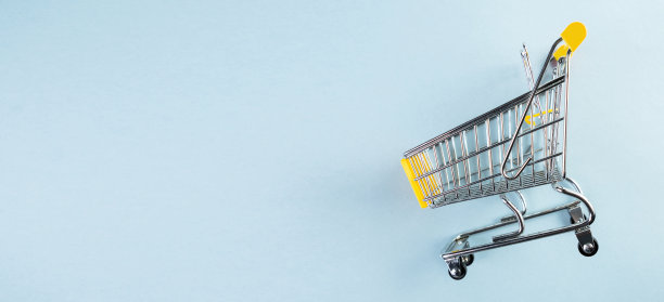 淡蓝色背景上的黄色空迷你购物车图片下载