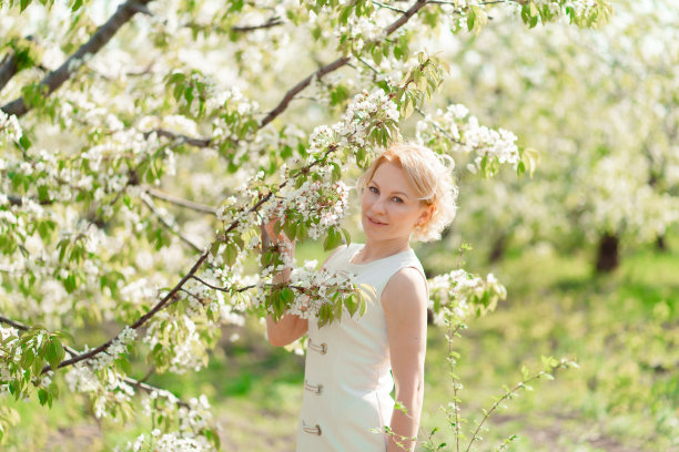 金发女孩拿着开花的树枝图片下载