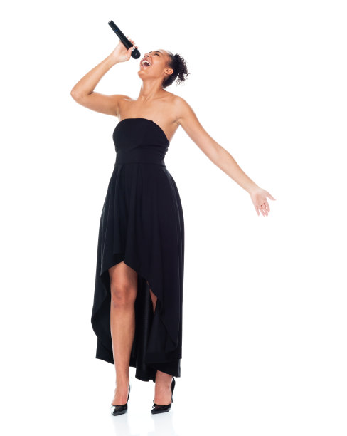 非裔美国女性穿着裙子手持麦克风在白人背景前跳舞图片下载