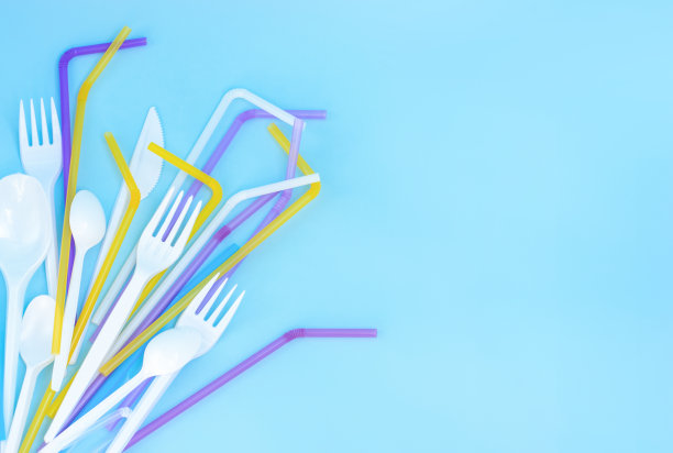 塑料垃圾，塑料器皿在蓝色背景下，平铺。拒绝一次性塑料。生态环境护理。为文本复制空间。图片下载