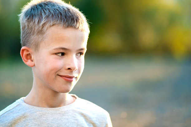 一个男孩的肖像在一个温暖的阳光明媚的夏天户外。图片下载