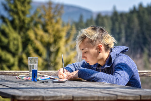 年轻女子在户外用彩色铅笔画画图片下载