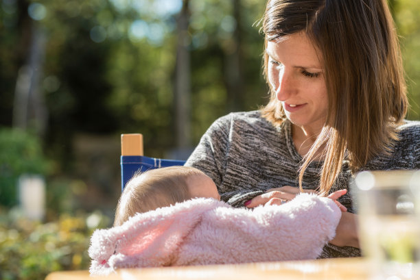 慈爱的年轻母亲正在给她的小女儿喂奶图片下载
