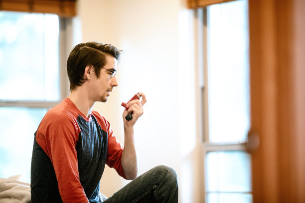 在室内使用吸入器的人图片下载