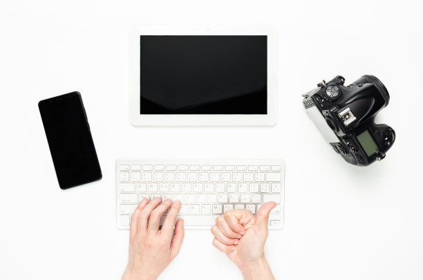 女人的手在用键盘，竖起大拇指。科技产品，平板电脑，相机，智能手机图片下载