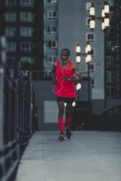 让曲线变平的夜间慢跑者:一个负责任的资深男士在可能产生社交距离的晚上跑步图片下载