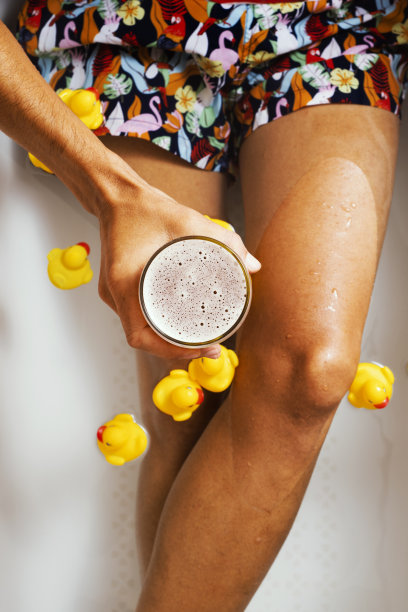 浴缸里拿着一杯啤酒的男人图片下载