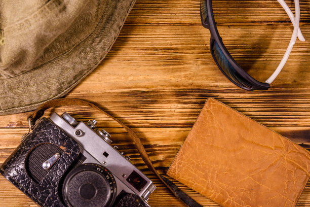 时髦的帽子、老式相机、太阳镜和木制背景的护照。俯视图图片下载