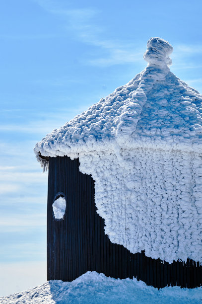 在巨人山脉的一个木制教堂的屋顶上的雪帽图片下载