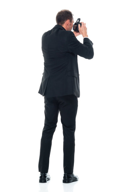 白人男性游客身穿商务装，手持相机站在白色背景前图片下载
