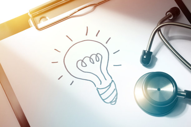 医疗创新在医生的医疗报告剪贴板上的灯泡图画和听诊器的特写图片下载