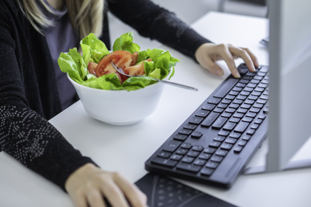 近距离的年轻女子吃和工作在家库存照片图片下载