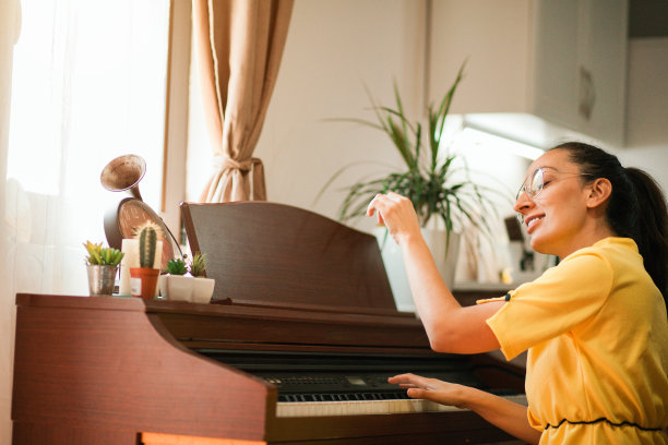年轻女子在家庭房间里弹钢琴图片下载