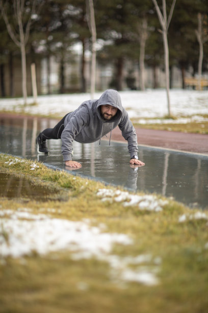 一个年轻的运动员在雨中锻炼的照片图片下载