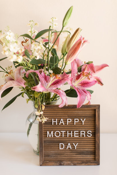 “母亲节快乐”的告示牌被粉红色的复活节百合花包围着图片下载
