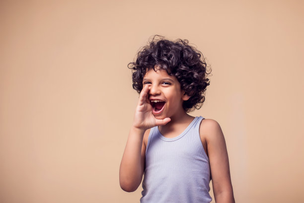 微笑的男孩做出呼喊的手势，儿童情绪概念照片图片下载