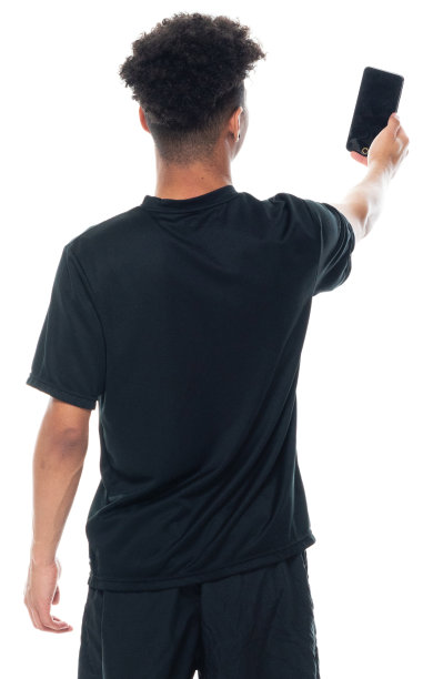 非裔美国青年男性摄影穿着运动鞋和使用手机站在白色背景图片下载