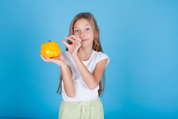 漂亮的小女孩拿着甜椒图片下载