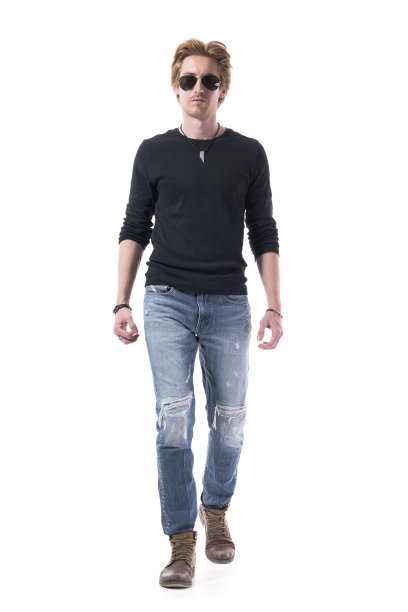 严肃自信的红发男时尚模特戴着墨镜走向镜头。图片下载