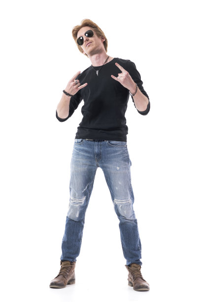 年轻的红发英俊的摇滚男子显示硬摇滚手手势在相机。图片下载