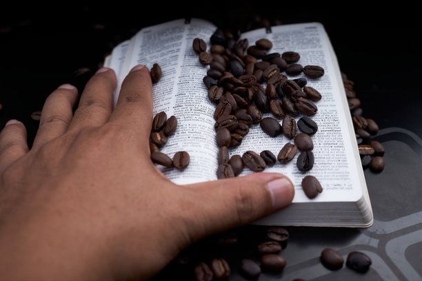 新鲜烘培的咖啡豆和一本黑色背景的书图片下载