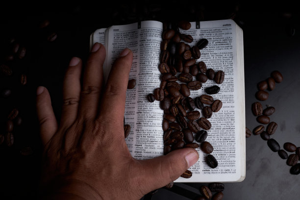 新鲜烘培的咖啡豆和一本黑色背景的书图片下载