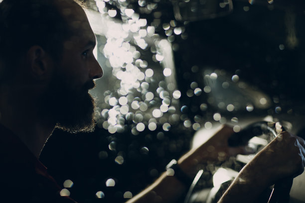 司机晚上坐在汽车的方向盘旁图片下载