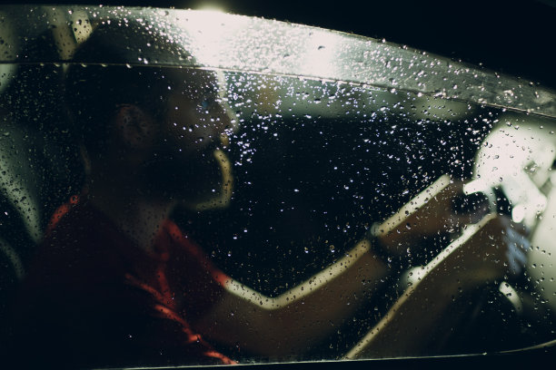 司机晚上坐在汽车的方向盘旁图片下载