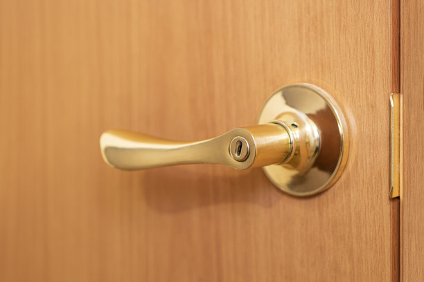 门的元素。倾斜的门把手在金色的背景木门。图片下载