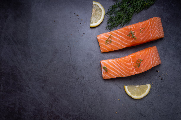 生鲑鱼片，迷迭香和酸橙，在深色石板背景，野生大西洋鱼。美味的鱼的肉。俯视图图片下载
