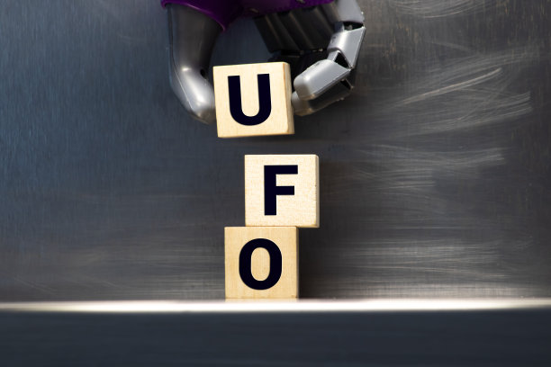 UFO的缩写，代表不明飞行物，拼写为木质字母瓷砖在白色的背景。图片下载