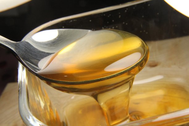 蜂蜜从勺子里流出的特写照片图片下载