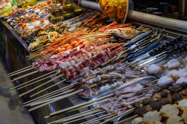 中国的街头食品。场外交易。中国海南省三亚市的一个亚洲海鲜市场里的各种中国新鲜海鲜。铭文:食品名称。图片下载