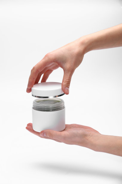 女人的手，女孩拿着一个打开的奶油罐，特写，白色背景，拷贝空间，文字，俯视图。图片下载