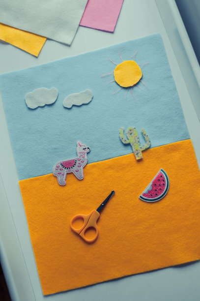 孩子在做拼贴画。从彩纸上剪出形状，粘在基础层上。用剪刀工作，提高工艺技能。图片下载