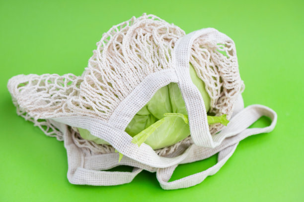 绿色背景的卷心菜和小胡瓜的网袋图片下载