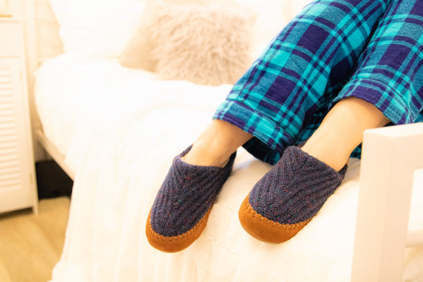 人们懒洋洋地躺在床上，穿着蓝色的睡衣和舒适的蓝棕相间的拖鞋。图片下载