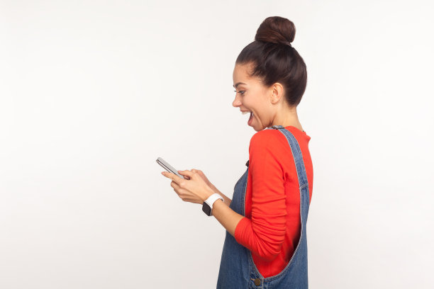 哇，很棒的手机应用!侧视社交媒体用户，女孩用惊讶的脸阅读手机信息图片下载