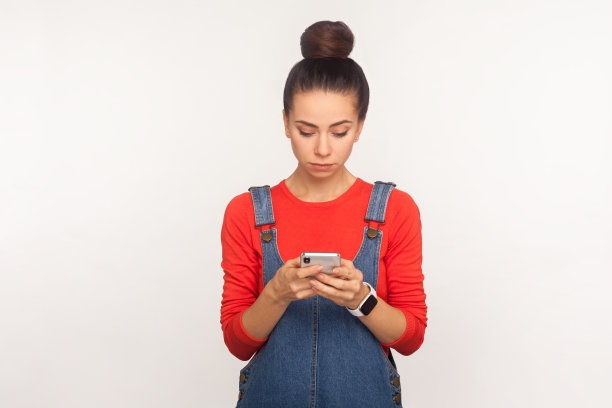 移动应用程序和在线交流。社交媒体用户的肖像，严肃的女孩在手机上发短信，聊天图片下载
