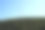 建筑起重机出现在绿色植物的墙上。蓝色的天空背景。图片下载