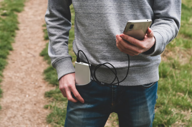 一名年轻人在户外用手机充电。现代技术的概念。有选择性的重点。图片下载