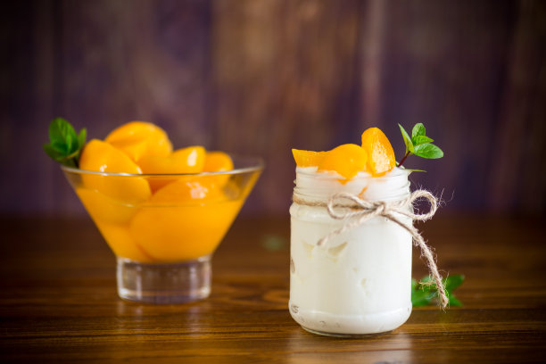 自制的甜酸奶和腌渍桃子片在玻璃罐中图片下载