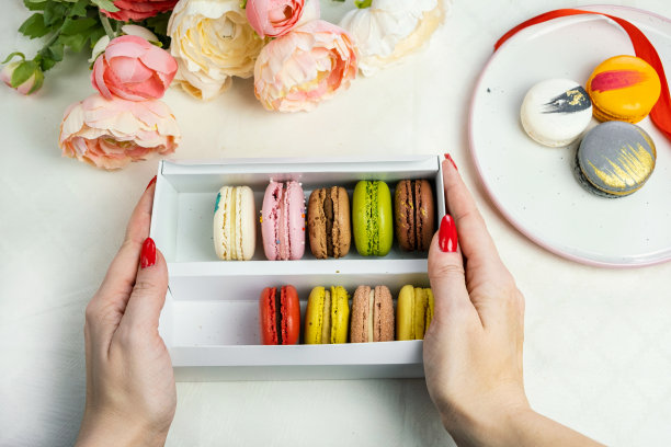 彩色现代杏仁饼干在礼盒在女性的手和盘子庆祝浪漫的派对生日图片下载