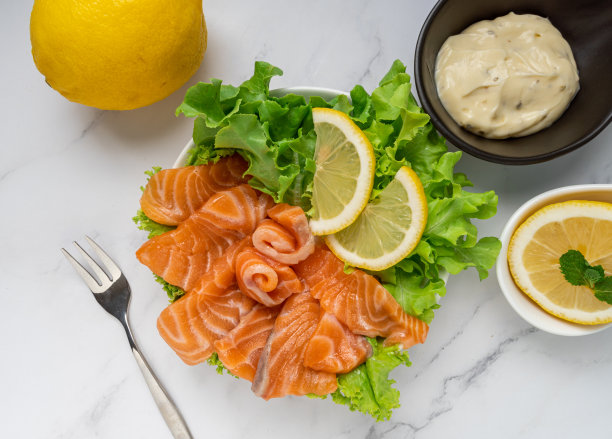 生三文鱼片或三文鱼生鱼片配青木沙拉，柠檬和日式白酱，白色大理石背景。俯视图图片下载