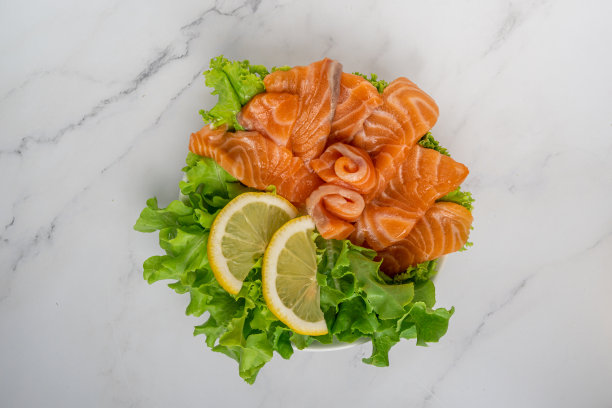生三文鱼片或三文鱼生鱼片配青木沙拉，柠檬和日式白酱，白色大理石背景。俯视图图片下载